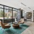 a room with a glass wall and a table with chairs and a bookcase with a bookcase