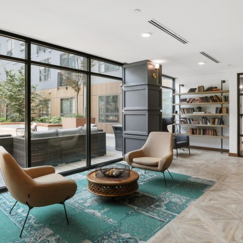 Find your perfect fit at Trellis House a room with a glass wall and a table with chairs and a bookcase with a bookcase