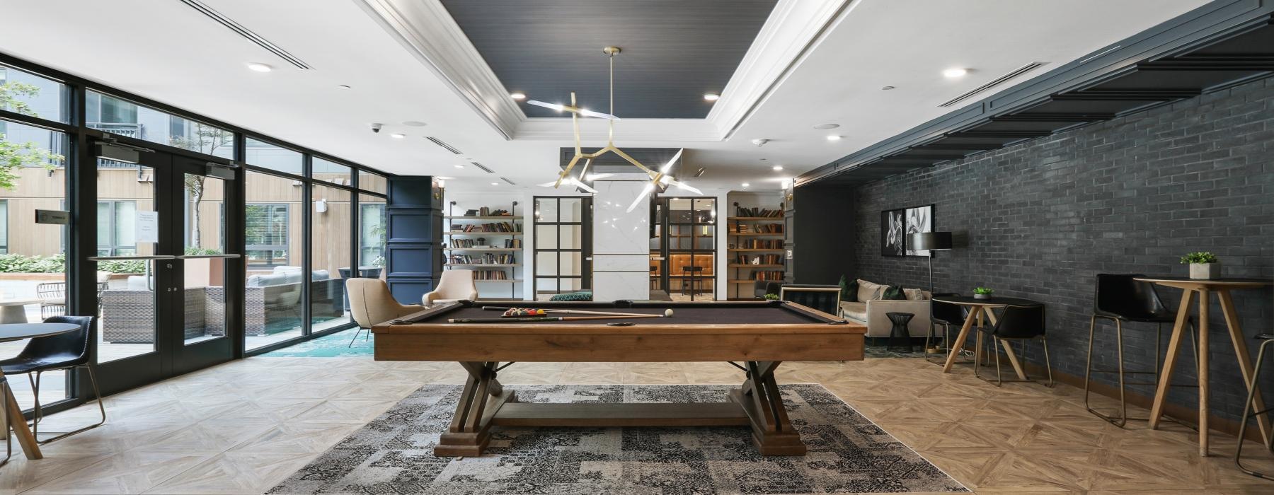 a room with a pool table and chairs