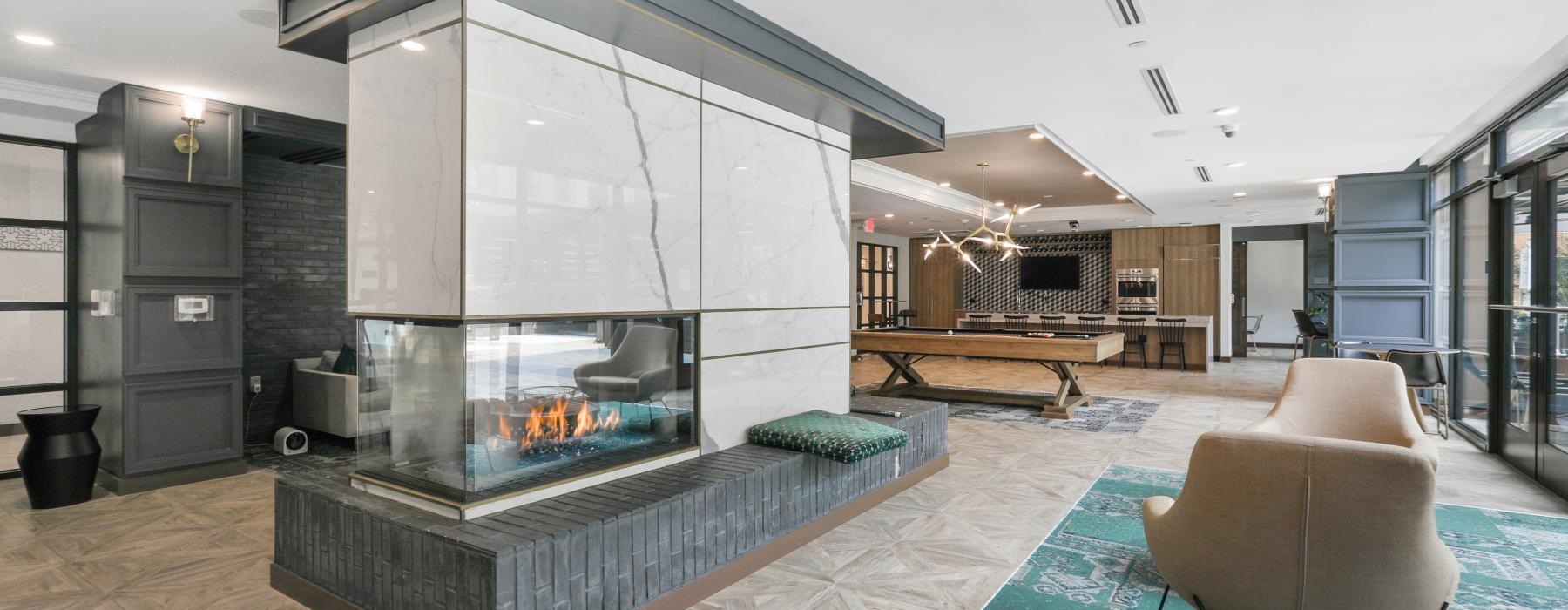 a modern looking living room with a large glass wall and a large fireplace
