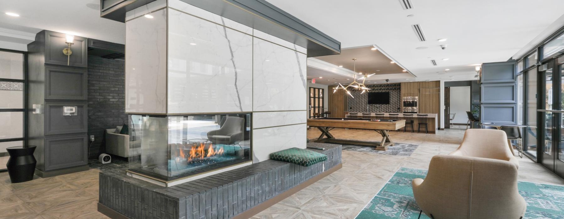 a modern looking living room with a large glass wall and a large fireplace